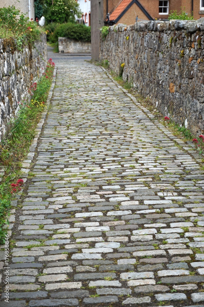 Ancient cobblestone walkway between stone walls