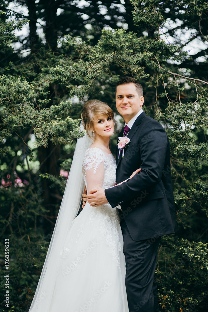 Happy wedding couple are posing near the old buildings Happy wedding couple are posing near the old buildings