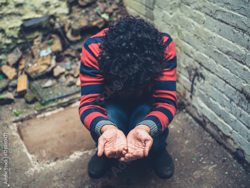 Young man with rash on hands begging photo