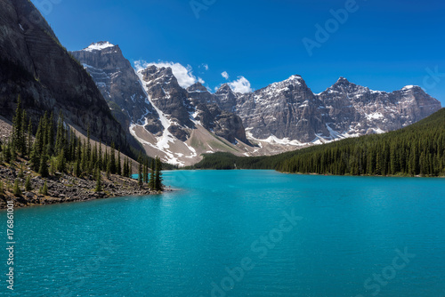 Beautiful turquoise waters of the Moraine Lake with snow-covered peaks above it in Rocky Mountains, Banff National Park, Canada.