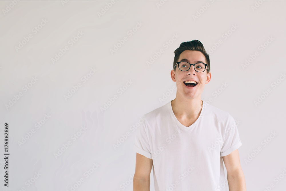 Man in white t-shirt and glasses with big smile isolated on white background. A very kind student has a good mood Man in white t-shirt and glasses with big smile isolated on white background. A very kind student has a good mood