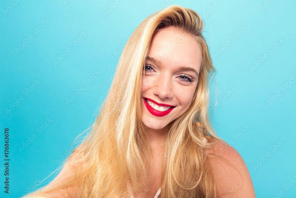 Fototapeta premium Young woman taking a selfie on a solid background