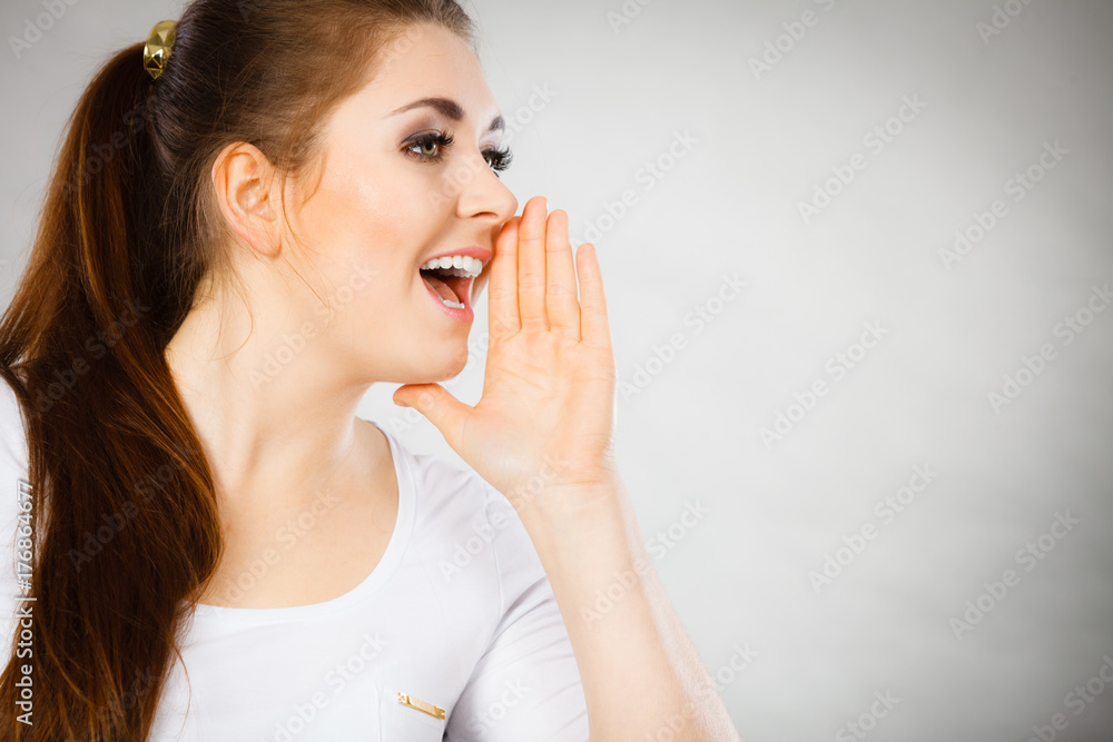 Woman talking gossip with hand close to lips Woman talking gossip with hand close to lips