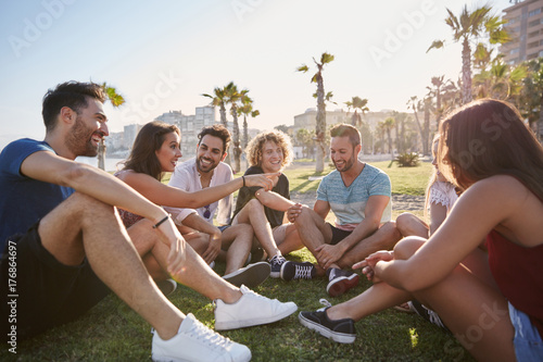 Group of friends sitting outside in circle talking