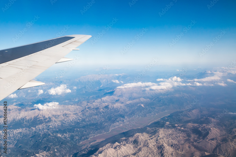 Wing of airplane flying above the Earth Wing of airplane flying above the Earth