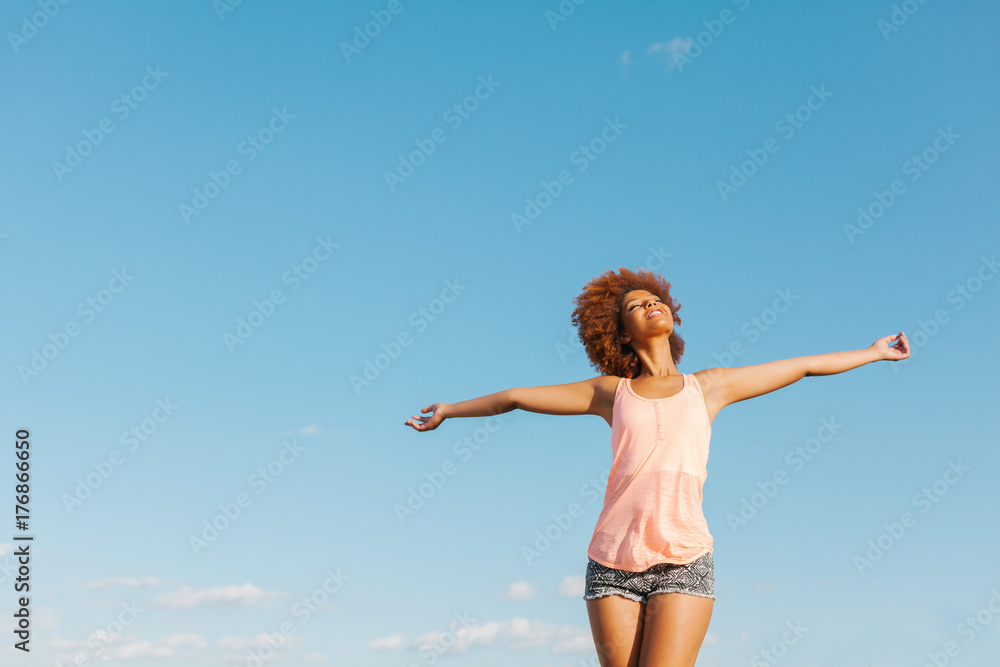 Latin American Afro Woman with Arms Wide Open in a Radiant Summer Day Latin American Afro Woman with Arms Wide Open in a Radiant Summer Day