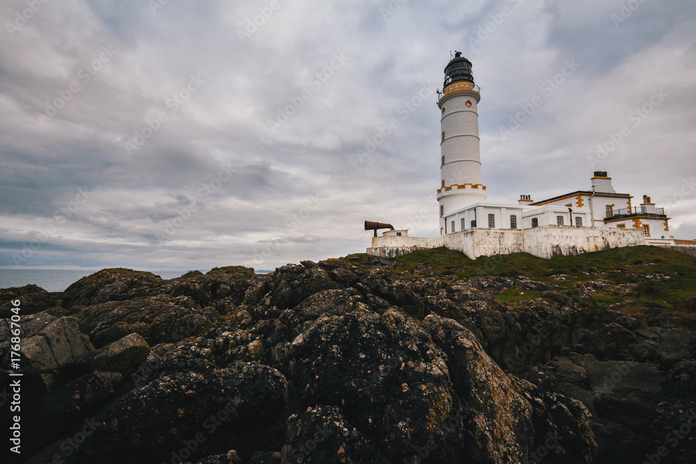 Old lighthouse on the rock coast of sea