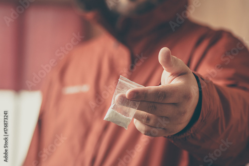 Drug dealer giving cocaine or another drugs to camera by hand. Criminal outlaw drug trade
