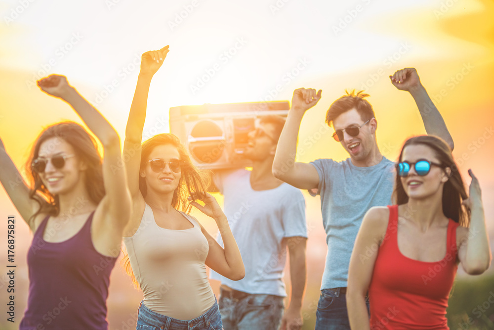 The happy people dancing with a boom box on the bright sun background The happy people dancing with a boom box on the bright sun background