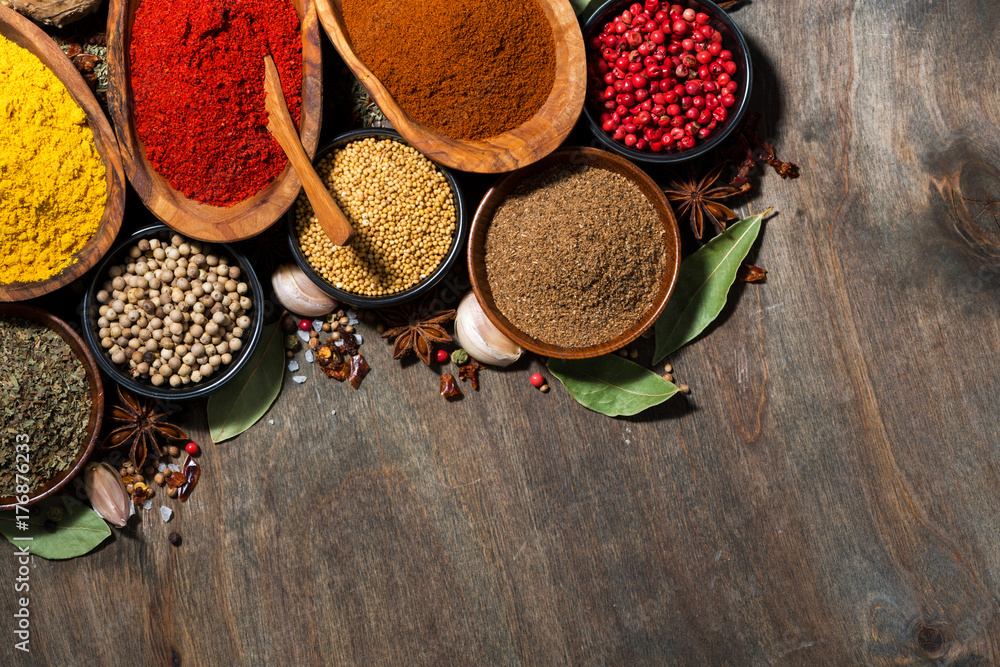 assortment of various spices on a wooden table, top view
