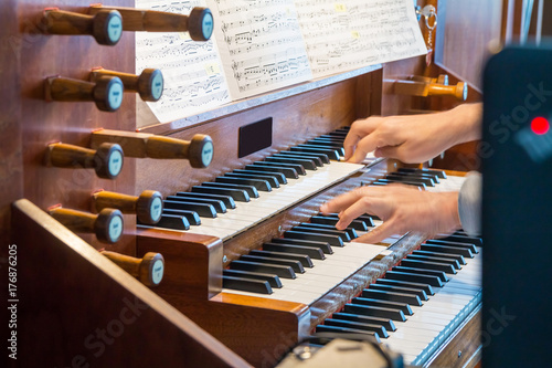 Foto Close up view of a organist playing a pipe organ