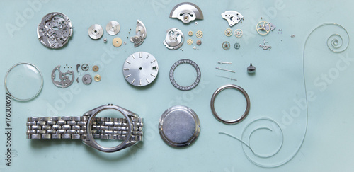 Parts of deconstructed watch lying on table photo