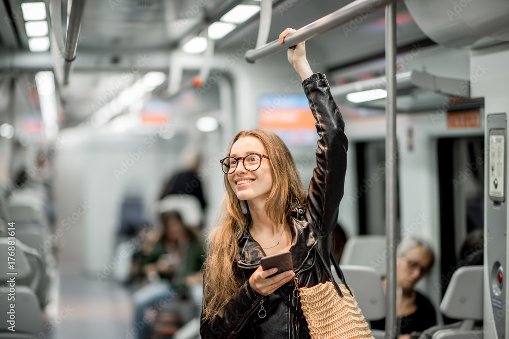 Lifestyle portrait of a young businesswoman standing with smart phone at the modern train Lifestyle portrait of a young businesswoman standing with smart phone at the modern train