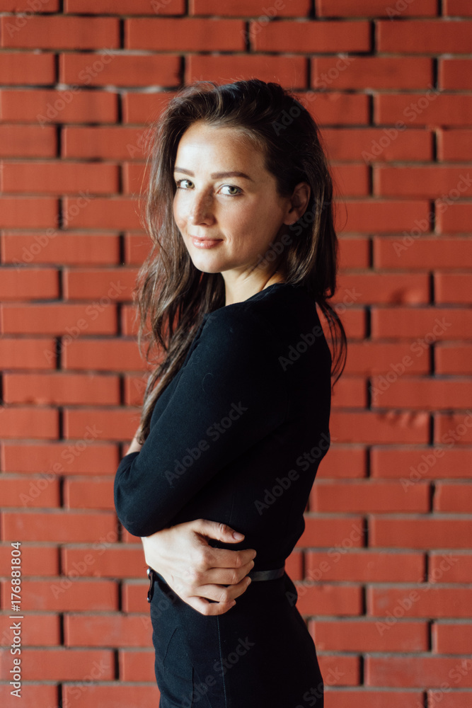 Beautiful woman portrait against the brick wall Beautiful woman portrait against the brick wall