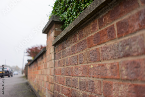 Garden wall running along side a pathway in a city