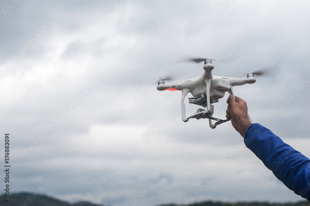 The flying drone copter with digital camera and human hand The flying drone copter with digital camera and human hand