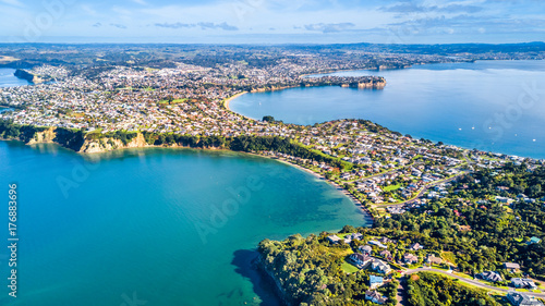Aerial view on residential suburbs surrounded by sunny ocean harbour. Whangaparoa peninsula, Auckland, New Zealand photo