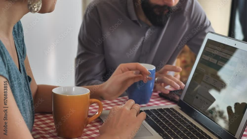 close up details woman and man sitting at the table in cafe or kitchen using laptop. Unrecognizable people have meeting. invisible girl typing on computer close up details woman and man sitting at the table in cafe or kitchen using laptop. Unrecognizable people have meeting. invisible girl typing on computer