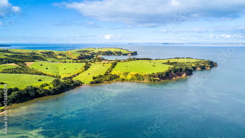 Aerial view on a farmland on the shore of sunny harbour. Whangaparoa peninsula, Auckland, New Zealand photo