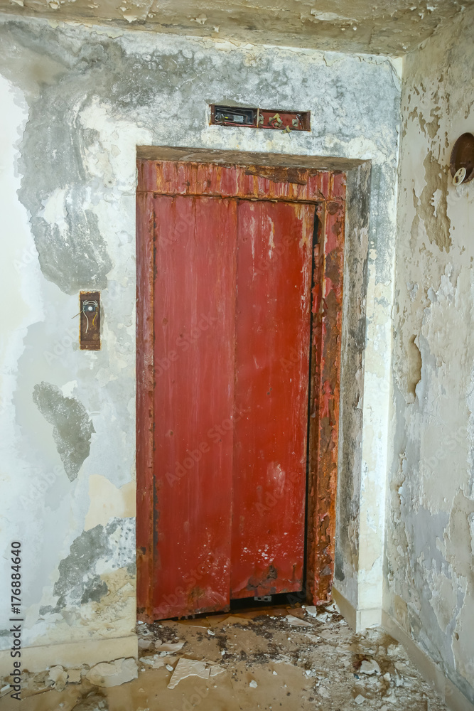 The red doors of an old ruined hotel.