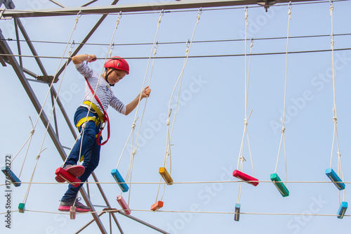 Little girl climbing on an outdoor ropes course.