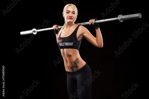 Sporty beautiful woman doing fitness exercising at black background to stay fit. Fitness workout motivation.