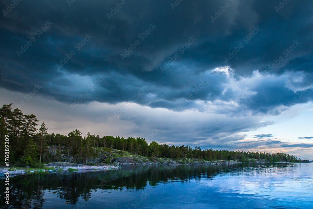 Thunderclouds. Weather spoils. Karelia. Russia. Ladoga lake. Evening in Karelia on the shore of the Ladoga lake.