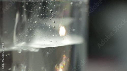 Closeup shot of pouring water from bottle into glass.