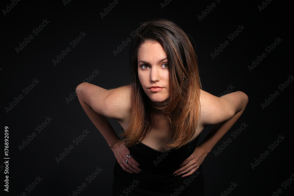 Seductive girl in a black dress leaning forward Seductive girl in a black dress leaning forward