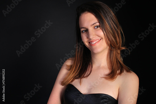 Seductive girl in a black dress smiling