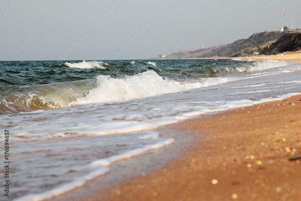 Stormy sea background.Waves and splashes.Sandy beach.