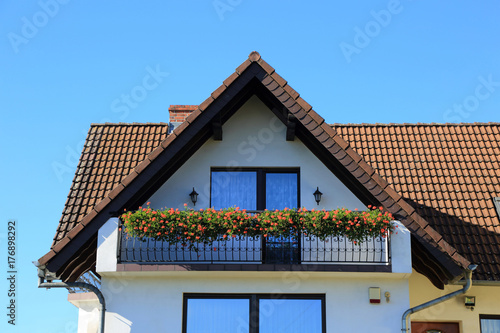Balkon z kwiatami w domu jednorodzinnym.