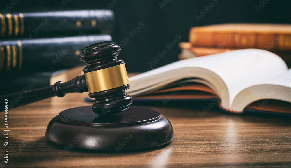 Judge gavel on a wooden desk, law books background Judge gavel on a wooden desk, law books background