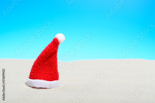 Santa hat on a Sunny beach. Close-up