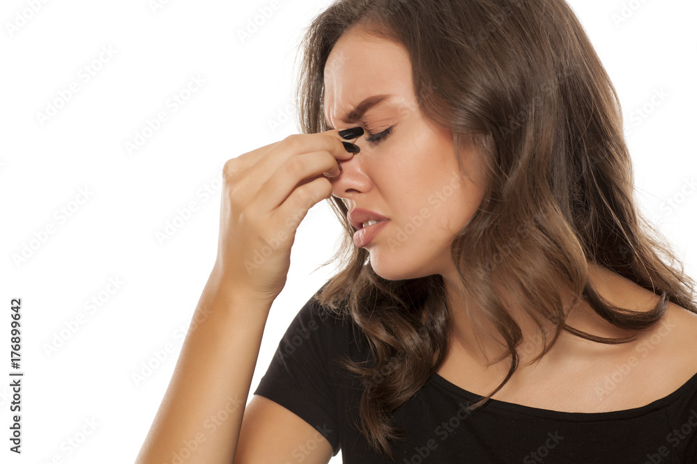 Beautiful young woman has a pain in the sinuses on white background Beautiful young woman has a pain in the sinuses on white background