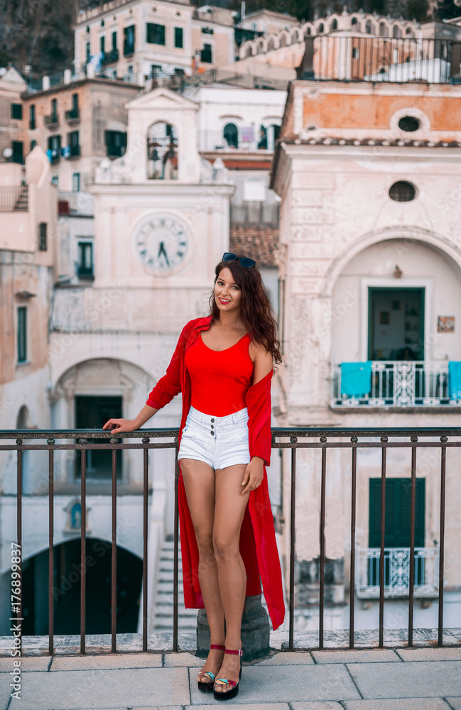 Fashion portrait of a young beautiful girl in red bikini and white shorts in Atrani, Amalfi coast, Italy, Europe