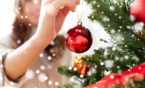 Obraz na plátně close up of woman hand decorating christmas tree