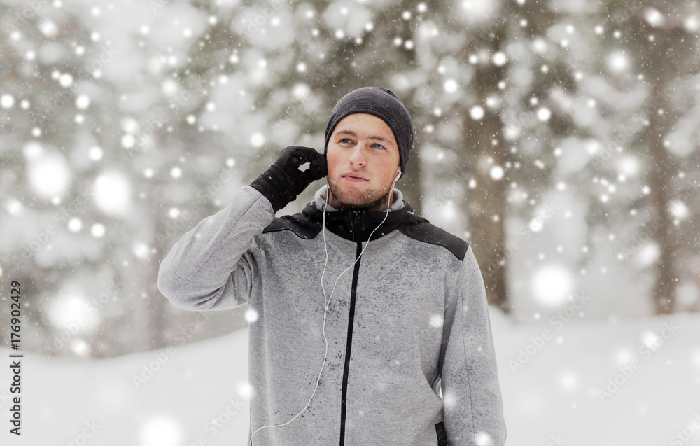 sports man with earphones in winter forest