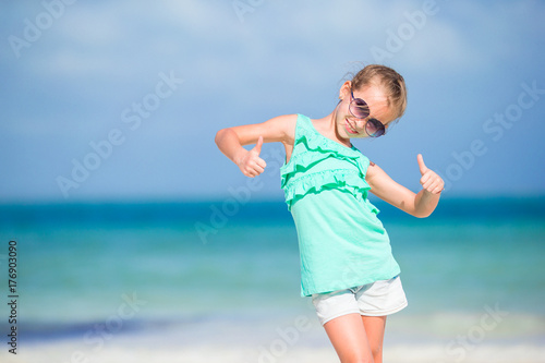 Active little girl on white beach having fun. Closeup kid background the sea