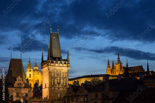 View of lit Lesser Town Bridge Towers, St. Nicholas Church and Prague (Hradcany) Castle at the Mala Strana (Lesser Town) in Prague, Czech Republic, in the evening. Copy space.