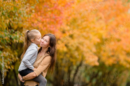 Family of mother and little kid outdoors in park at autumn day
