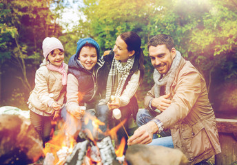 happy family roasting marshmallow over campfire