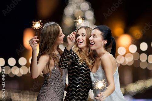 happy young women with sparklers at new year night