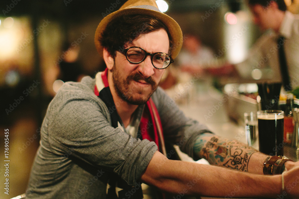 Portrait of a man with a fedora and scarf making a funny face Portrait of a man with a fedora and scarf making a funny face