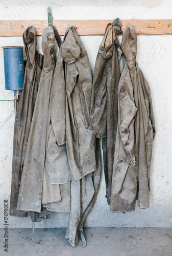 Used and Destroyed waterproof workwear hanging on hangers photo