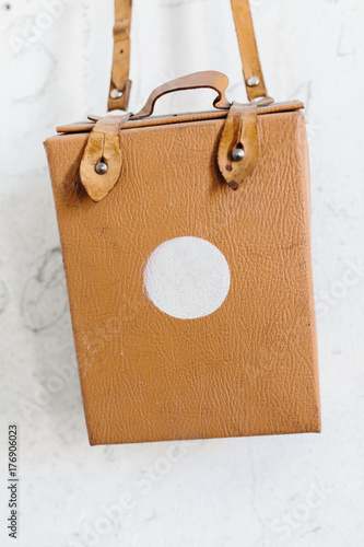 Portable first aid kit hanging on white wall photo