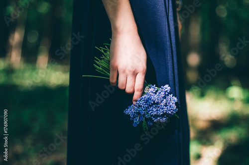Hand holding sheaf of blue flowers