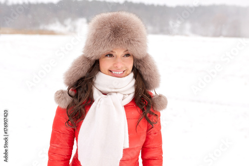 happy woman in winter fur hat outdoors