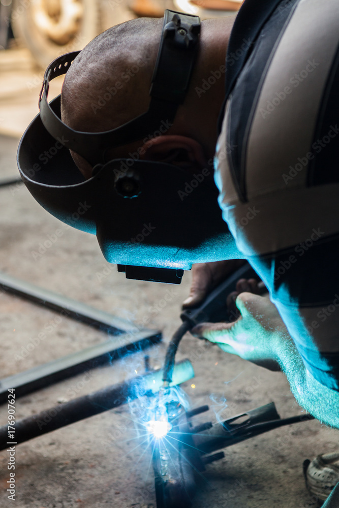 Car mechanic welding car part with torch. Car mechanic welding car part with torch.