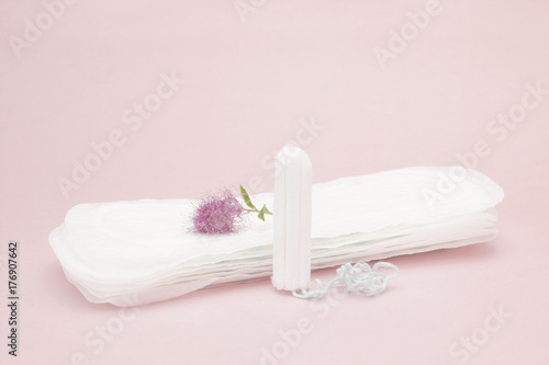 Pink flower, menstrual sanitary tampon and pads. Woman critical days, gynecological menstruation cycle. Menstruation sanitary woman hygiene for blood period. Hygienic conceptual photo.